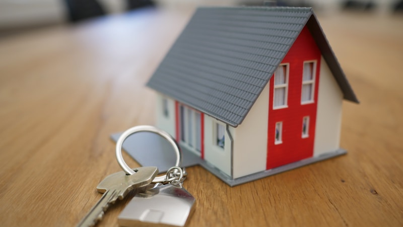 Small model house with keys representing home buying